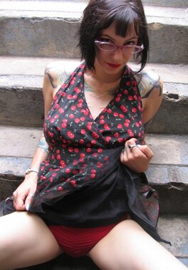 Female with glasses and piercing in clitoris demonstrates her naked body