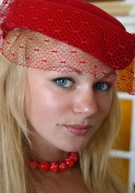 Chesty young blonde with a red hat on demonstrates her amazing curves