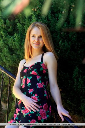 Teen redhead starts taking dress off on the stairs and poses nude on the balcony
