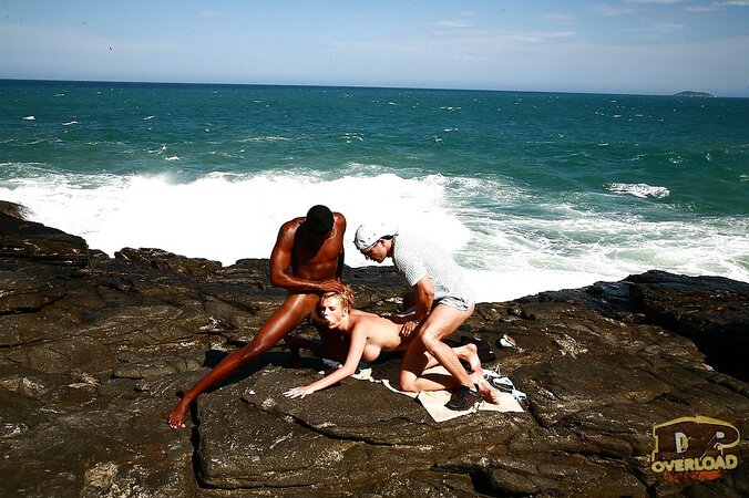 Busty blonde MILF double penetrated on rocky coast by white and black guys