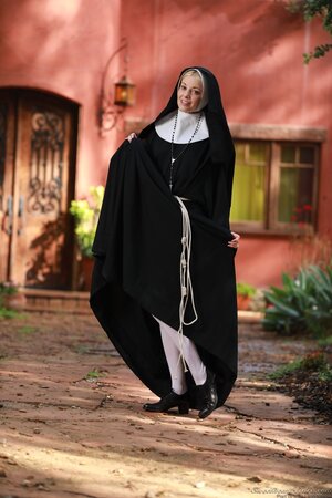 Slender blonde nun provocatively shows small tits and cunny hidden under outfit
