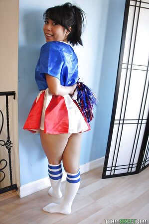 Oriental girl in cheerleader suit shows off small boobs and smooth muff