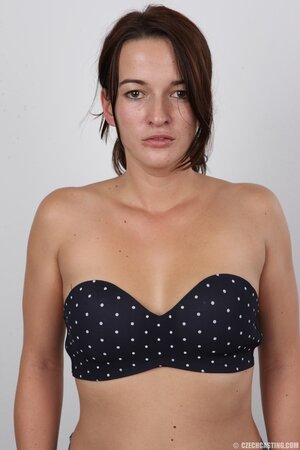 Female in polka-dot bra gets completely naked posing on the stool on camera