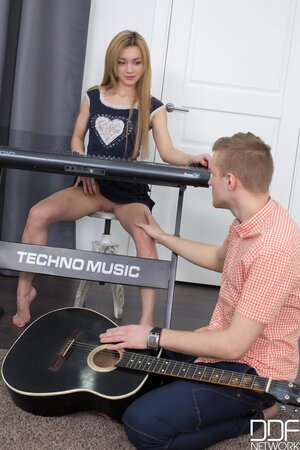 Piano girl satisfies guitar man being scored during rehearsal in the studio