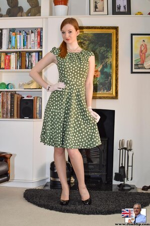 Female with red hair wears polka-dot green dress at the XXX photo shoot