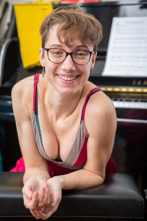 Hairy musician girl with glasses enjoys playing piano absolutely naked