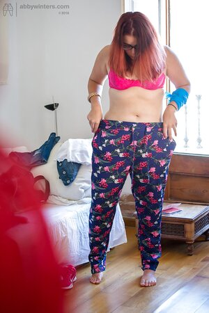 Plus-sized redhead on pink lingerie to get fully dressed next to the window