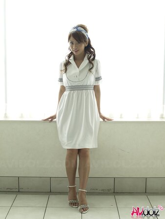 Modest Japanese sweetie dressed in white dress that accentuates her slimness