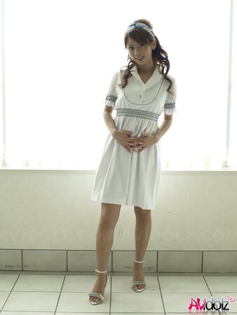 Modest Japanese sweetie dressed in white dress that accentuates her slimness