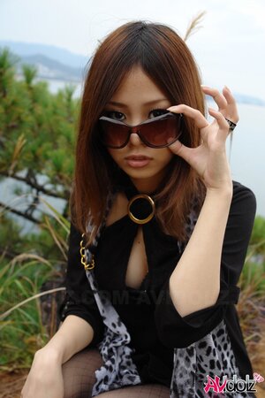 Asian girl with sunglasses on looks so seriously cause she is shy being naked