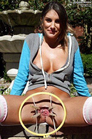 Sporty brunette with natural tits stretches pussy outdoors with a special device
