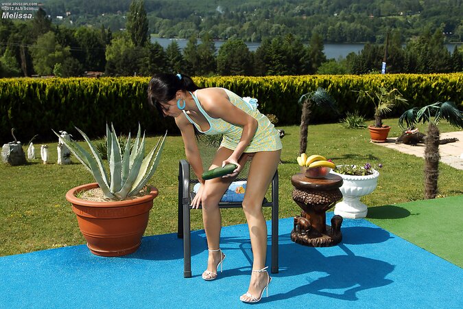 Vegan girl with ponytail spreads legs to insert big cucumber in her twat outdoors