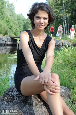 Short-haired babe seductively takes off black outfit while sitting by the pond