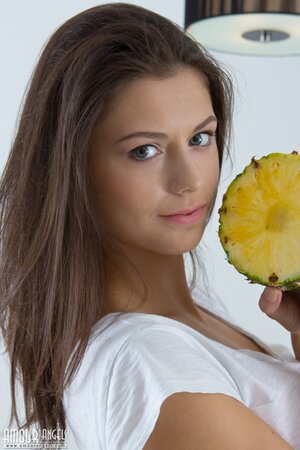 Young model with beautiful face uses cut pineapple to cover private parts