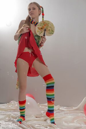 Fancy girl with red balloons and in striped socks bares her small fun parts