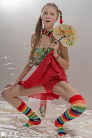 Fancy girl with red balloons and in striped socks bares her small fun parts
