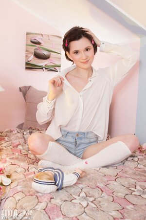 Adorable babe with short hair poses completely naked in her cosy bedroom