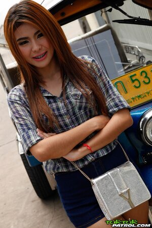 Exotic teen with red hair demonstrates her braces while posing near rickshaw