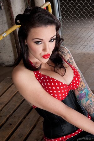 Inked goddess with juicy boobs poses like rockabilly diva in warehouse