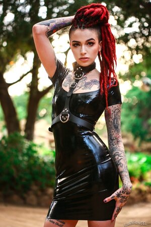 Goth girl in a vinyl dress poses on camera exposing her muff for cash