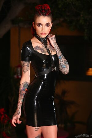 Goth girl in a vinyl dress poses on camera exposing her muff for cash