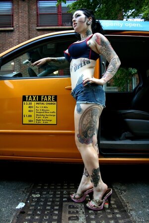 Tattooed cutie waits for a taxi driver and performs a naked show by his car