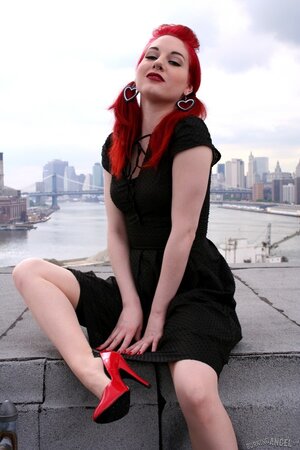 Tempting teen with red hair and high heels takes her black dress off on a roof