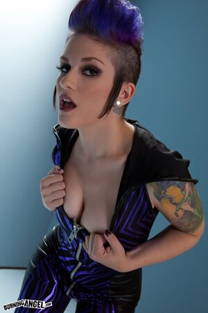 Purple mohawk and tattoos are a distinctive feature of this sexy chick
