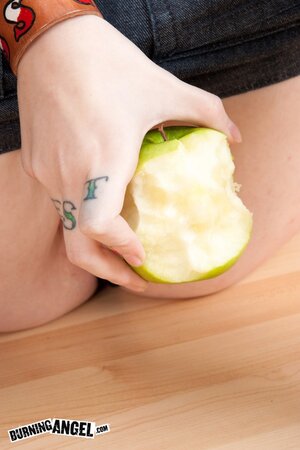 Tattooed coed with green locks eats an apple and fingers vagina on the floor