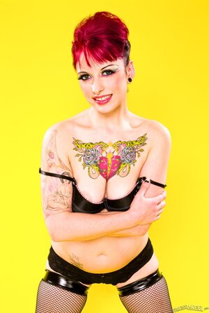 Sweetie with middle-sized boobs starts striptease on a yellow background