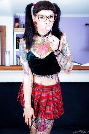 Pigtailed bookworm with ear stretching plugs and tattoos flashes private parts