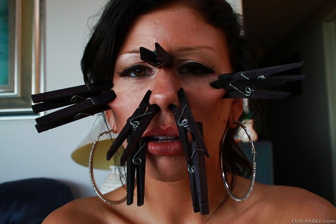 Woman demonstrates clothespins all over her face and a tail in her tushy