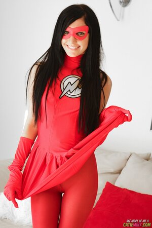Cutie dressed like a superheroine playfully shows her trimmed twat and small tits