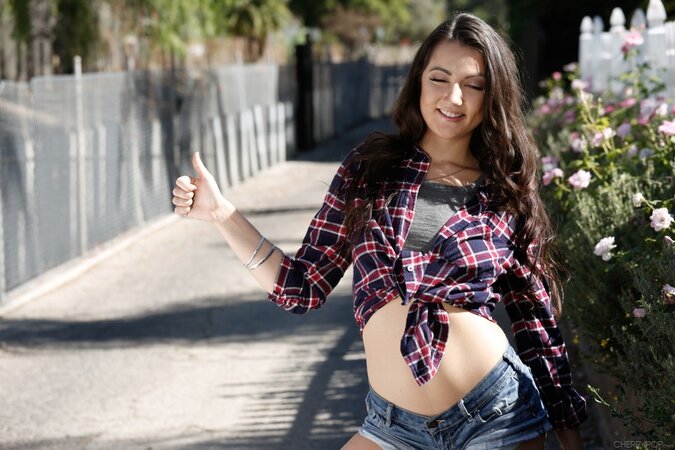 Young brunette in denim shorts flashes her small tits while hitchhiking