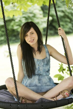 Seductive tender brunette undressing to show her awesome pussy on a swing