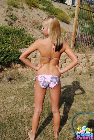 Sweet blonde slowly pulls sexy bikini down to demonstrate her slim body