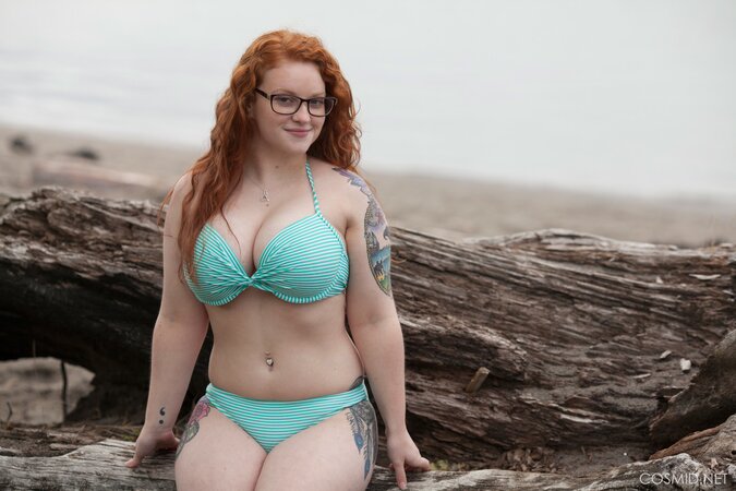 Plump ginger whore with glasses poses naked shaking her big tits outdoors