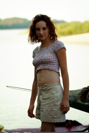 Slender girl with curly red hair and hirsute pussy undresses for pics on the boat
