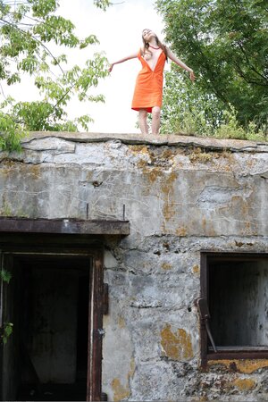 Innocent girl seductively peels off clothes during shoot on top of abandoned site