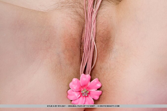 Small-tittied slut moves pink flower from the neck to her naked pussy