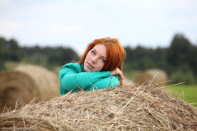 Torrid redhead demonstrates juicy cunt and small tits posing on the bale of hay