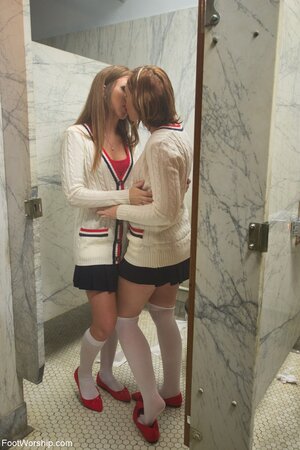 Red-haired lesbian schoolgirls take off socks and caress pink feet in the toilet