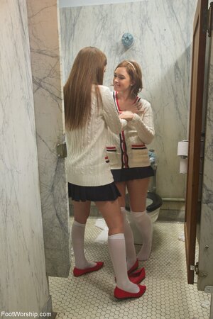 Red-haired lesbian schoolgirls take off socks and caress pink feet in the toilet
