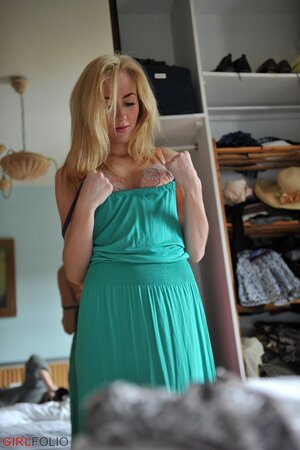 Charming blonde seductively poses while trying on clothes in the bedroom