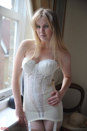 Gorgeous blonde discards vintage dress till she is left in corset and stockings