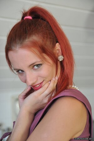 Pretty redhead doffs clothes and gets nasty for the camera in the kitchen