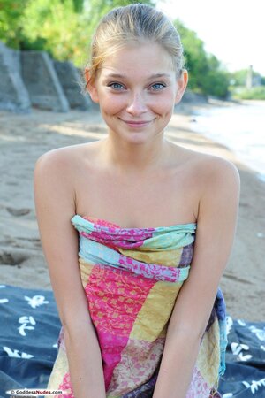 Innocent cutie with blue eyes is brave enough to reveal young body on the beach