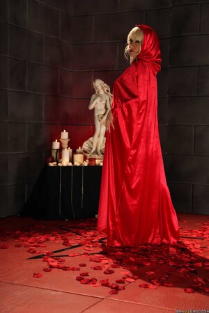 Blonde witch in heels slowly removes red gown and poses naked on the floor