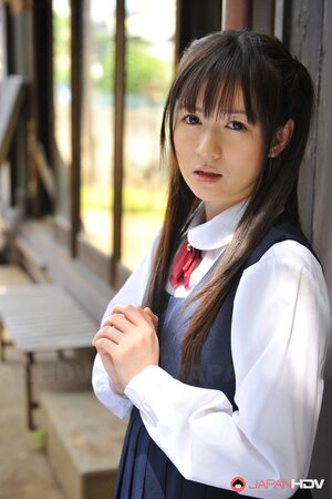 Innocent Japanese schoolgirl with beautiful eyes walks seductively under sun