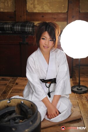 Cute young Japanese woman in a kimono participates in erotic photo session